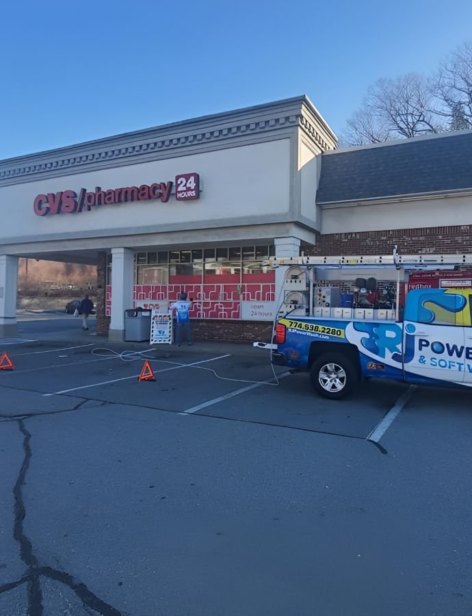 CVS pharmacy exterior being cleaned by a commercial power washing company. A blue truck with "Power & Soft Wash" is parked outside. Open 24 hours.